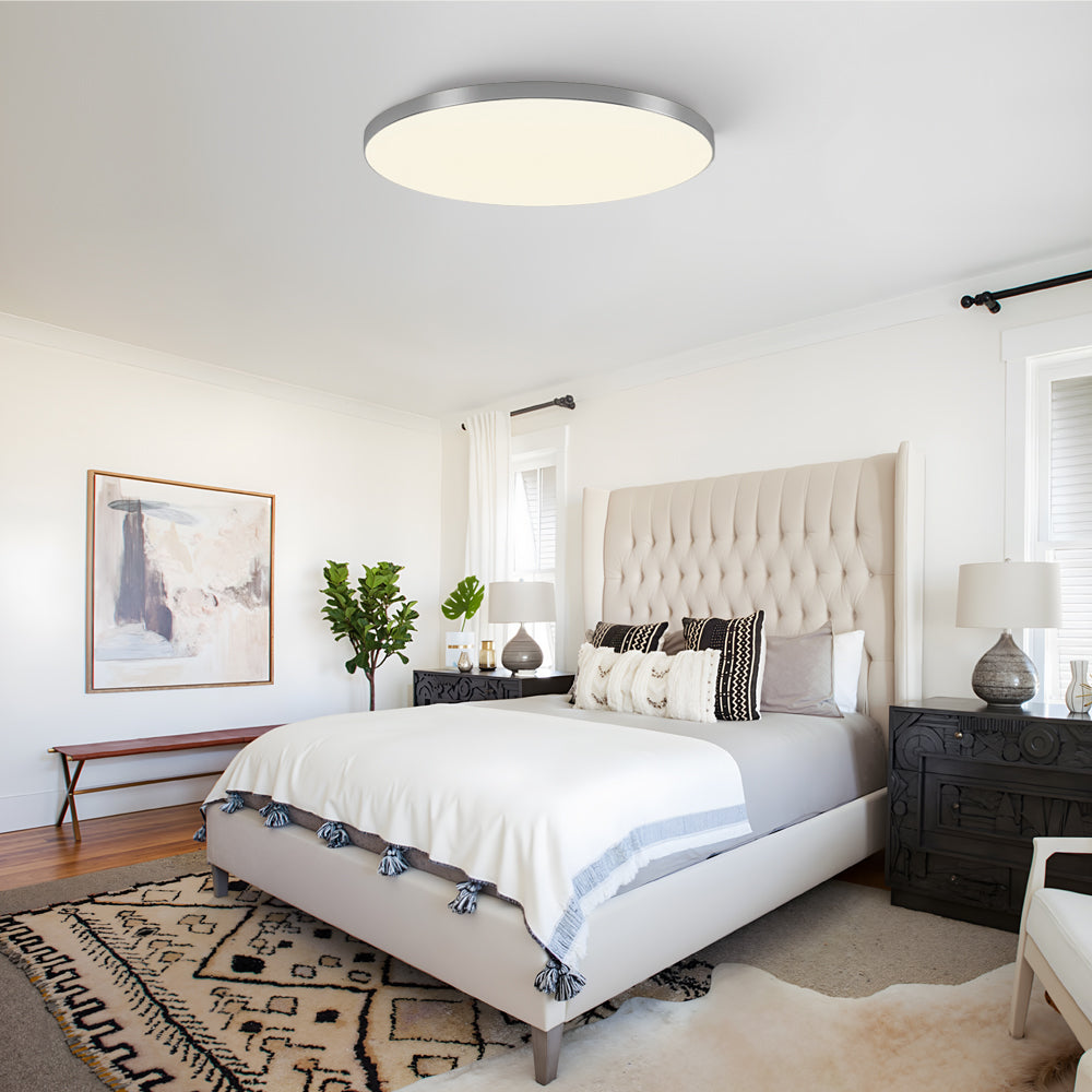 Silver minimalist LED flush mount ceiling light in a stylish bedroom with a patterned rug