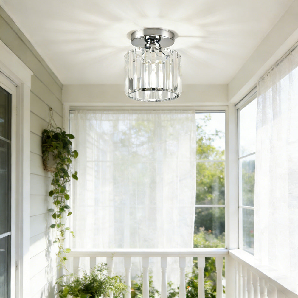 Modern silver round crystal flush mount fixture in a bright, sunlit entryway
