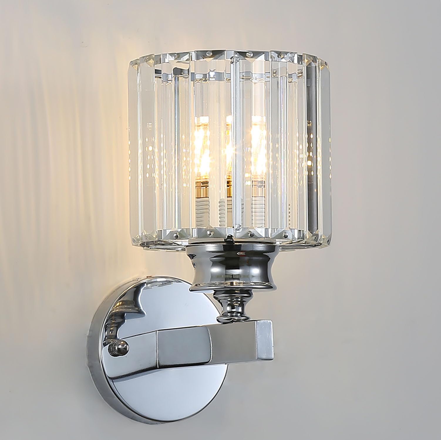 Modern silver round crystal wall sconce isolated against a neutral grey background