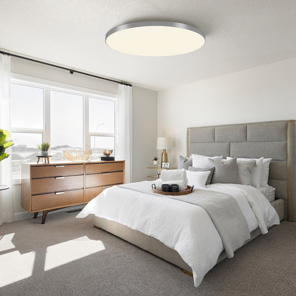 silver round LED flush mount ceiling light in a bright, airy contemporary bedroom