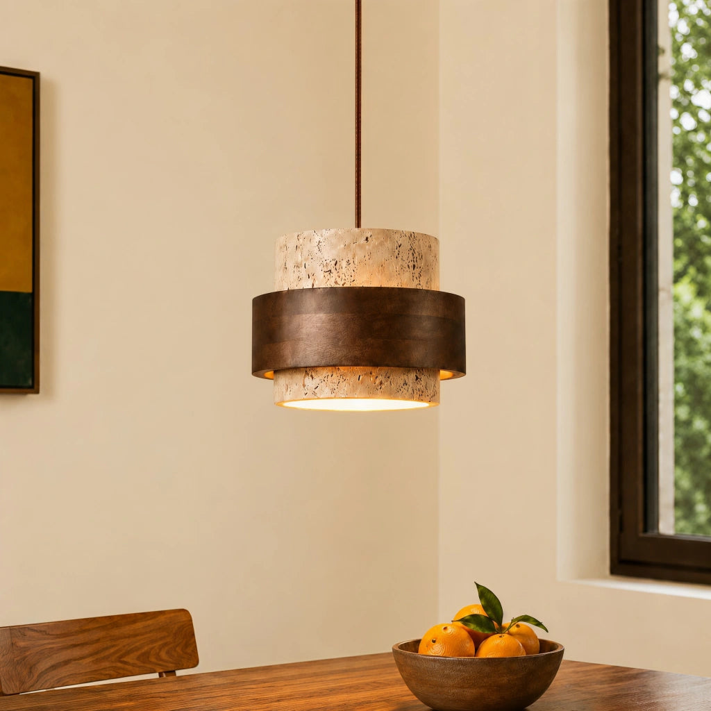 Single Japandi travertine stone pendant light with a dark wood band hanging over a dining table