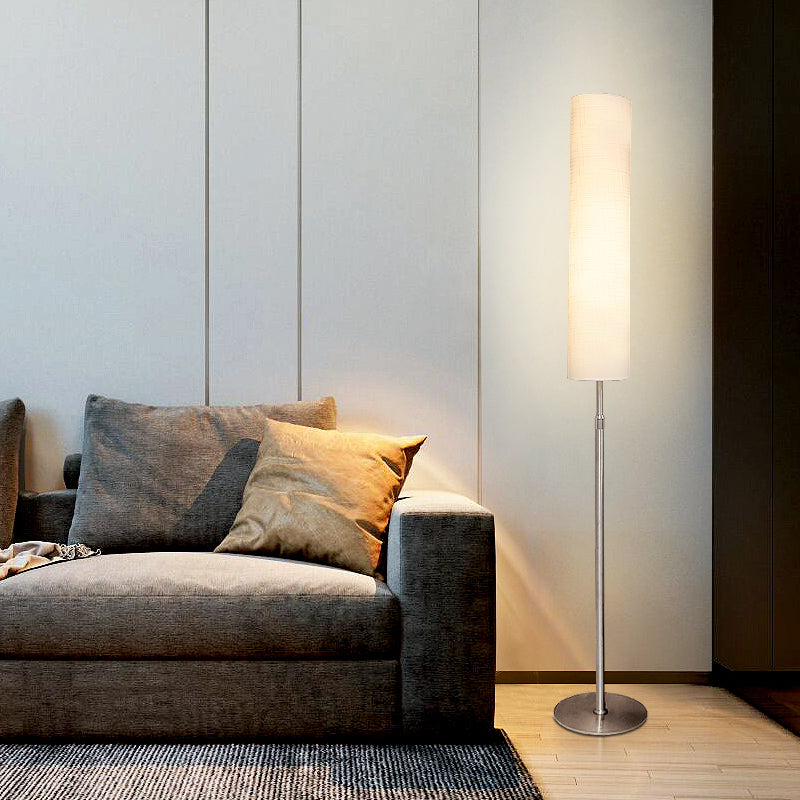 Sleek metal base floor lamp with a tall fabric shade in a minimalist living room lounge