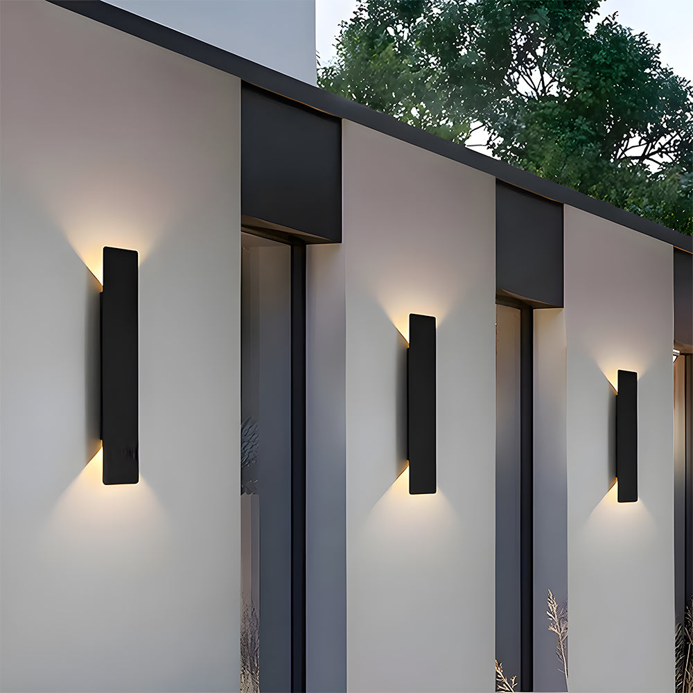 Three slim architectural exterior wall lights installed on a contemporary white facade