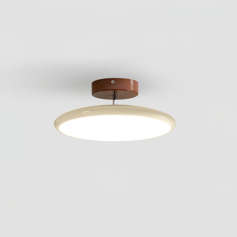 Small beige tilting LED ceiling fixture isolated on a clean background