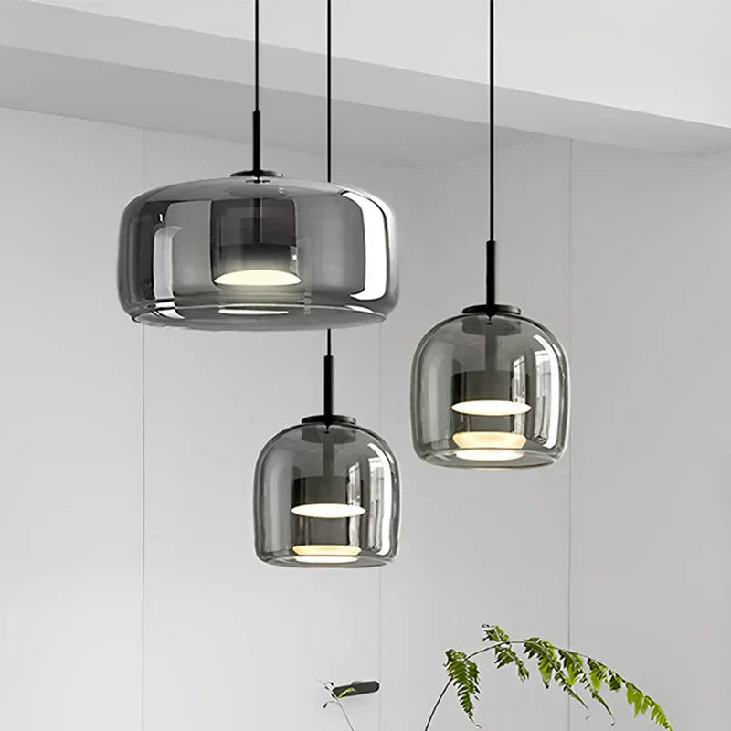 Three smoke grey double-layer glass pendants illuminating a contemporary kitchen island