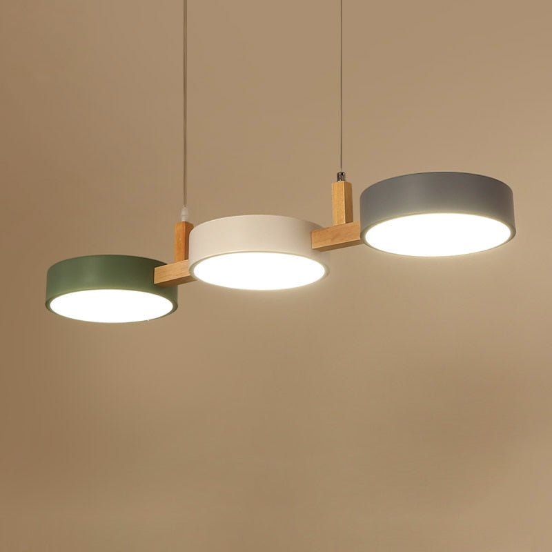 Solid 3 light Nordic linear chandelier hanging against a warm, neutral background