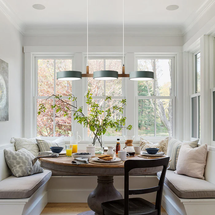 Solid green linear pendant light hanging in a bright, naturally lit dining nook