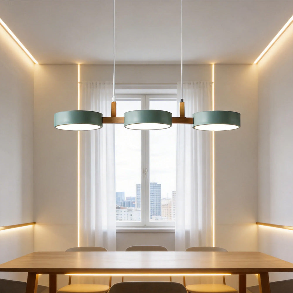 Solid green 3-light pendant providing warm light over a window seat dining area