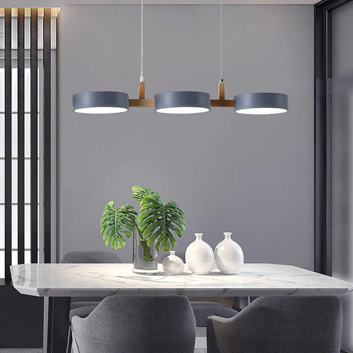 Solid grey 3-light pendant providing even illumination over a marble dining table