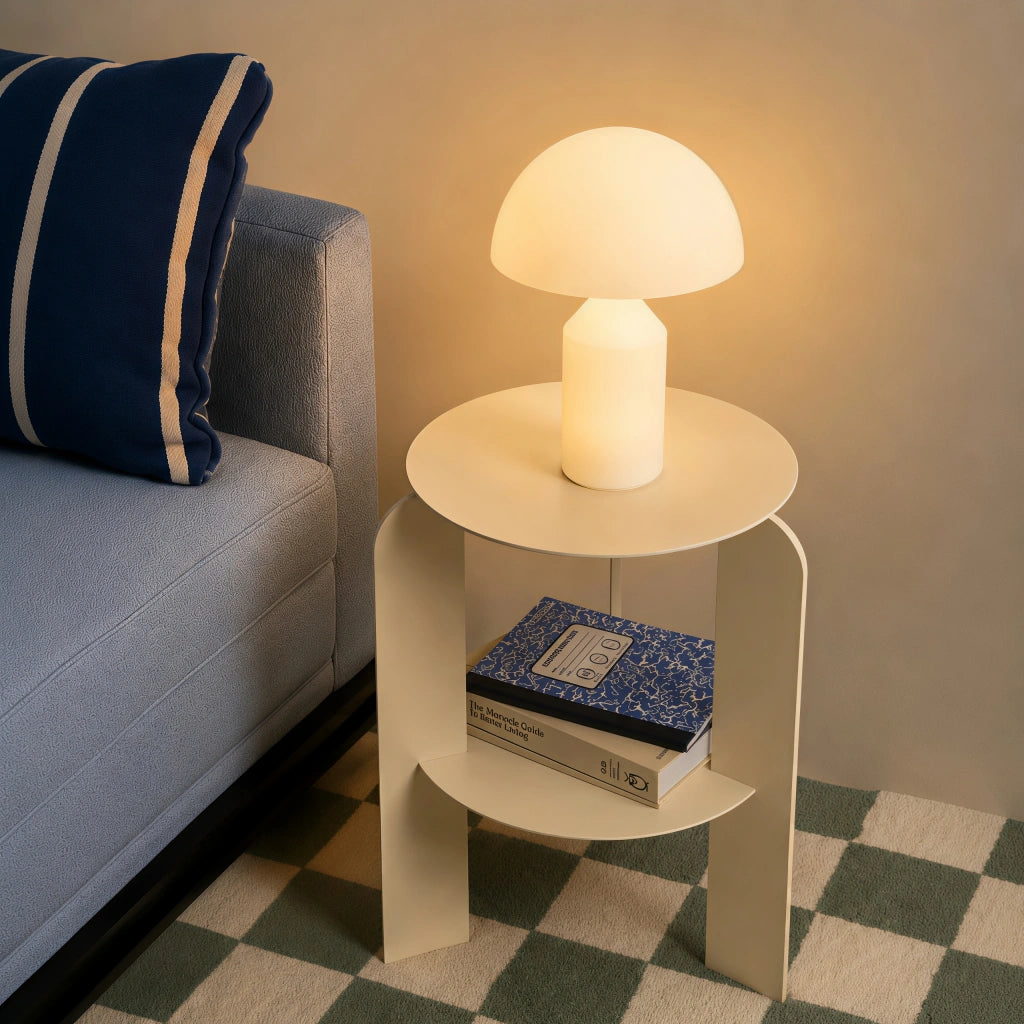 Space Age white mushroom table lamp acting as a minimalist bedside reading light next to a blue sofa