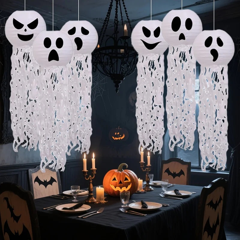 Spookballs ghost paper lanterns hanging above a dark Halloween dinner party table setting