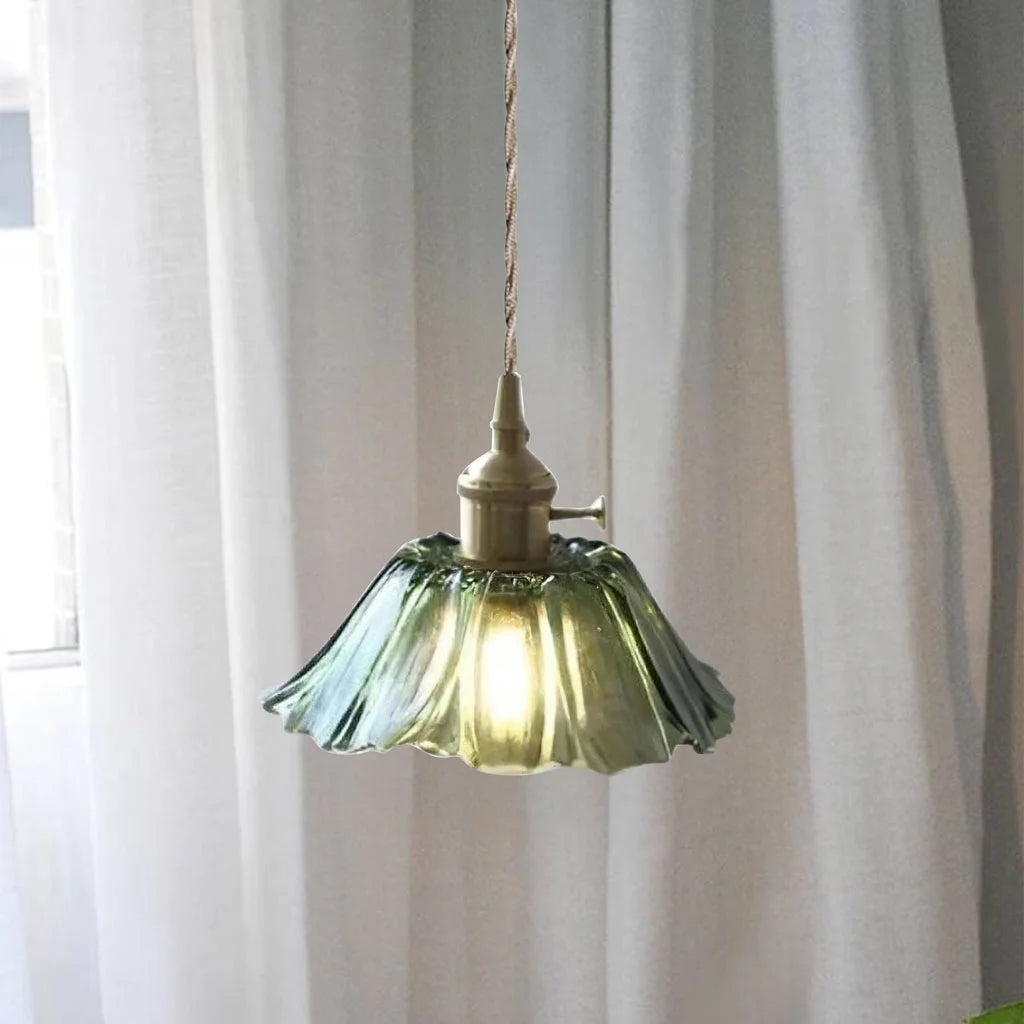 Tall green scalloped glass pendant light hanging gracefully against a sheer white curtain