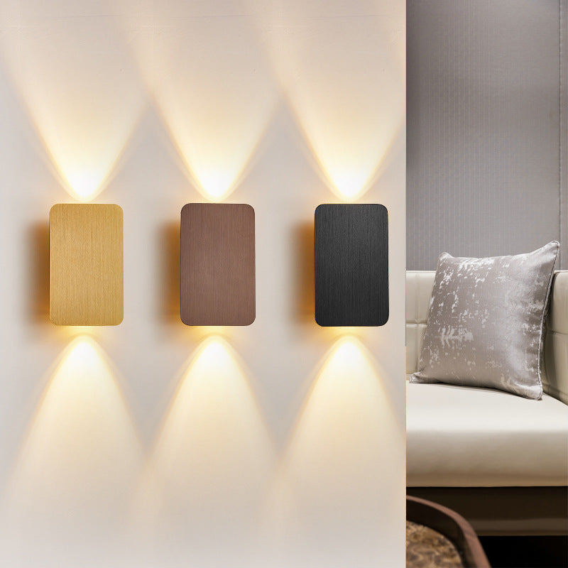 Three contemporary rectangular LED wall sconces providing ambient light above a living room sofa