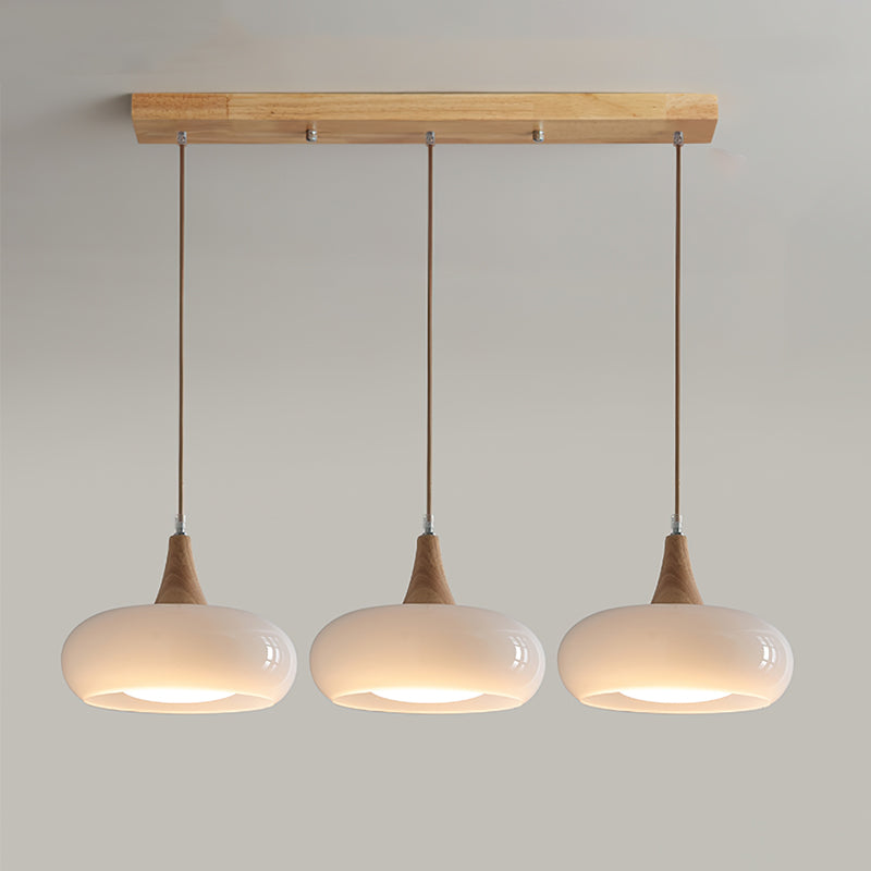 3-head white retro linear chandelier with wood accents isolated on a light grey background