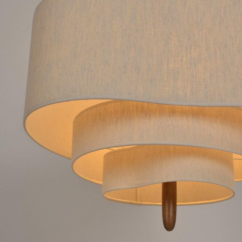 Underside view of the tiered linen pendant light showcasing its layered light diffusion and wooden pillar accent