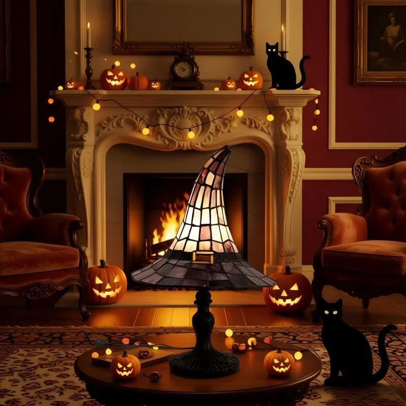 Tiffspell witch hat table lamp glowing by a fireplace with black cats and carved pumpkins