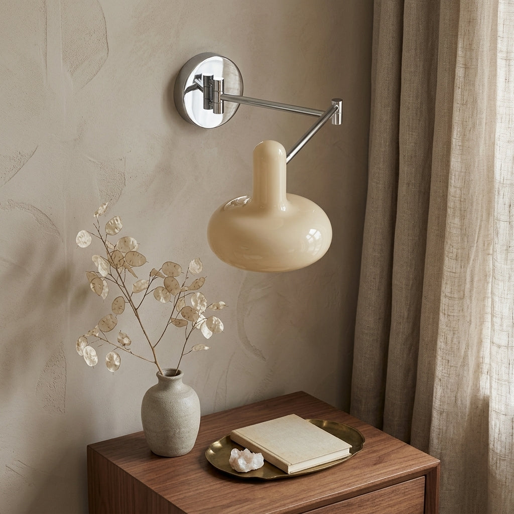 Tolzi cream wall sconce mounted above a nightstand with a small vase