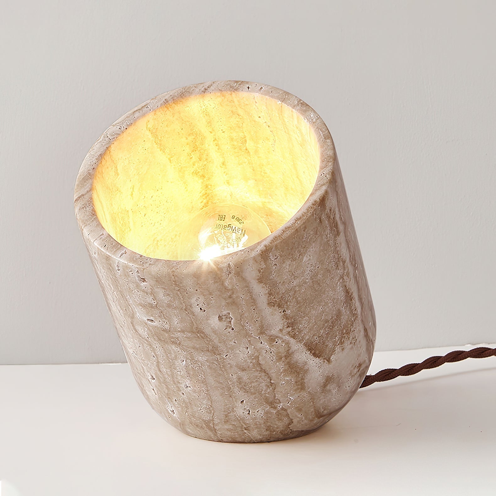 Top-down view into the travertine table lamp highlighting the raw stone rim and internal light source