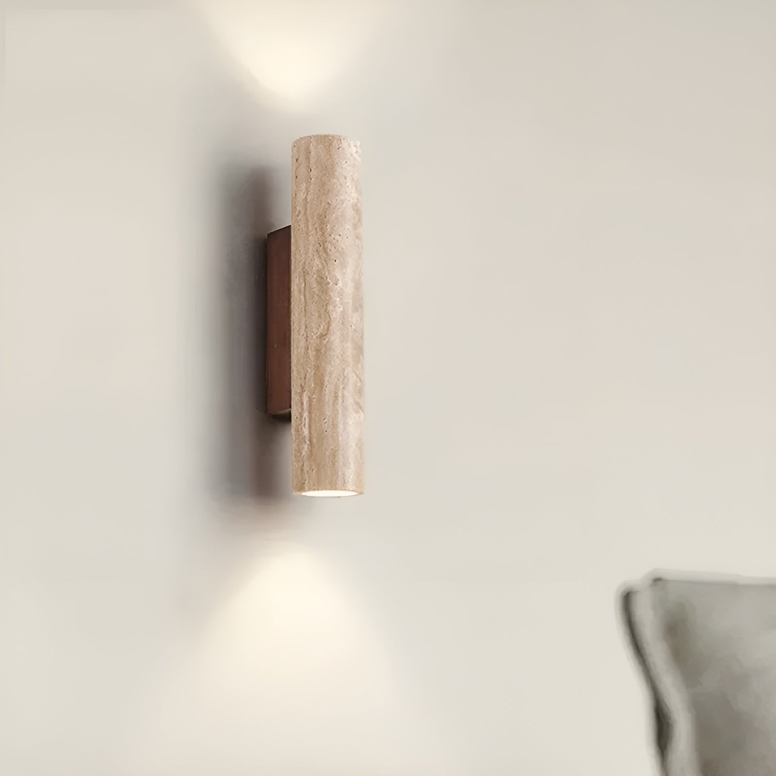 Travertine wall sconce mounted next to a grey sofa