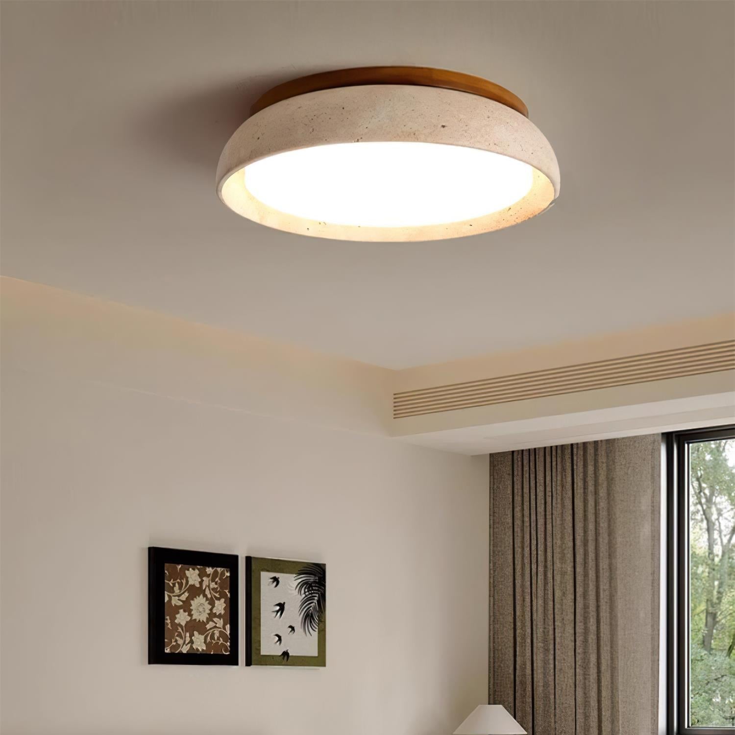 Travertine and wood LED ceiling lamp illuminating a bright room with framed art