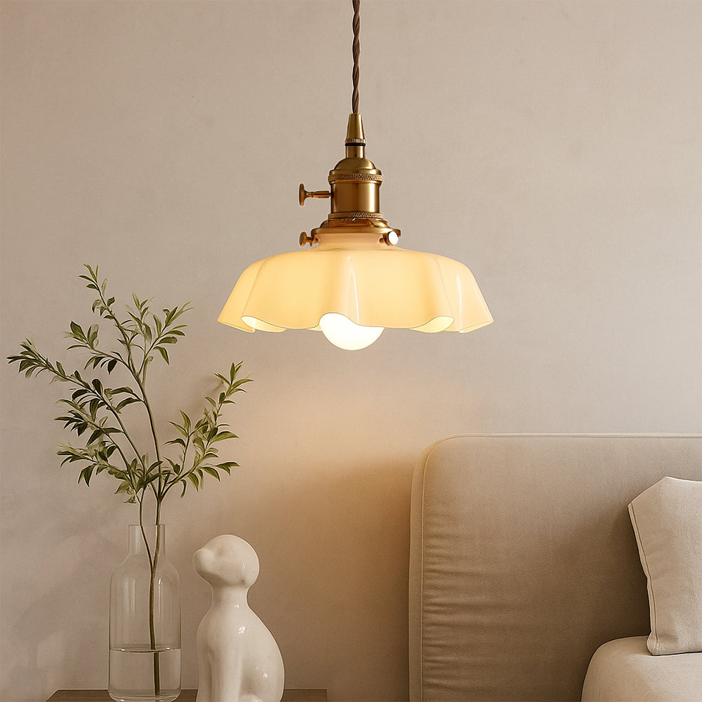 tugyl scalloped glass pendant light hanging next to a modern beige sofa and decorative statues