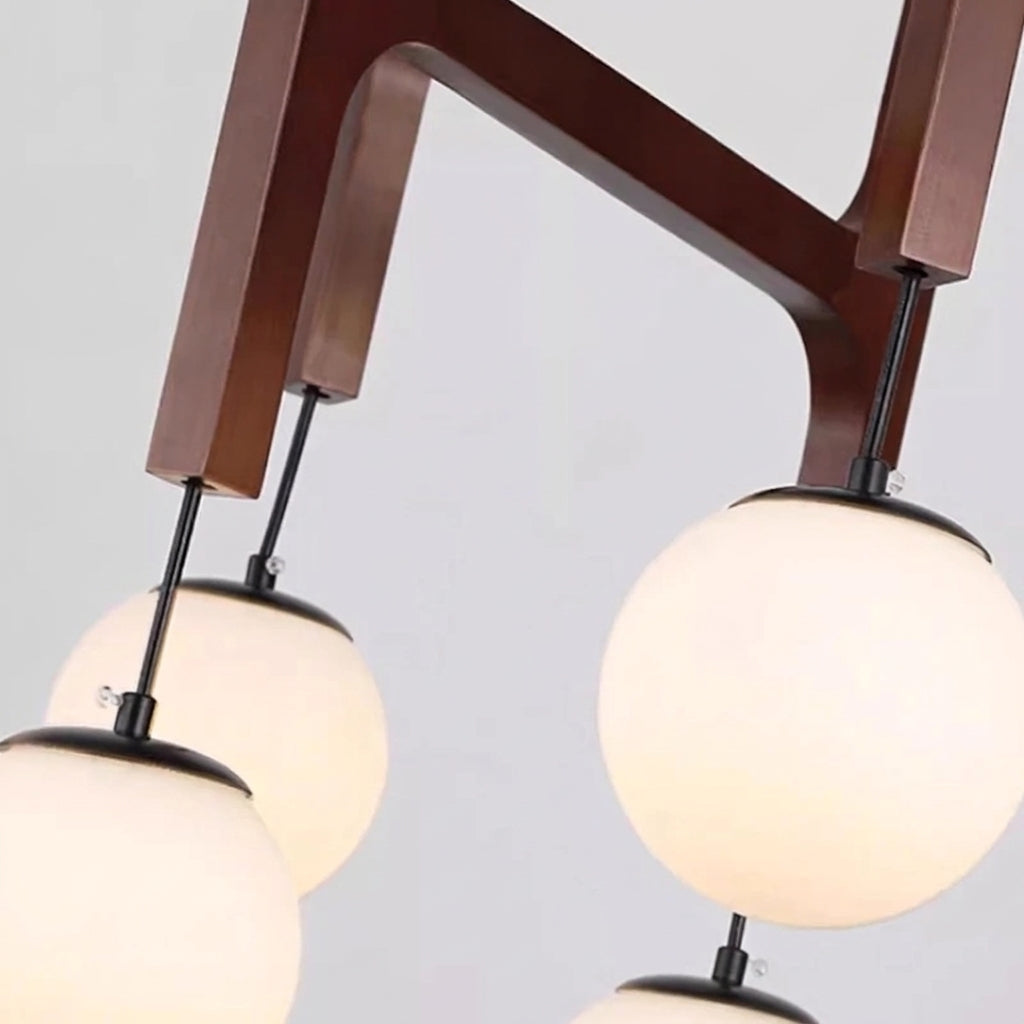 Close-up of Tuntla's solid wood branching arm and lit orb glass globes