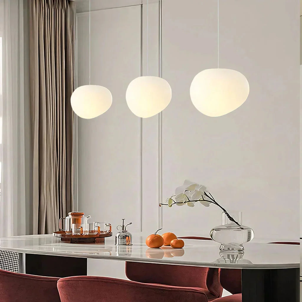 Linear cluster of three Wabi-Sabi frosted glass tupel pendant lights above a modern dining table