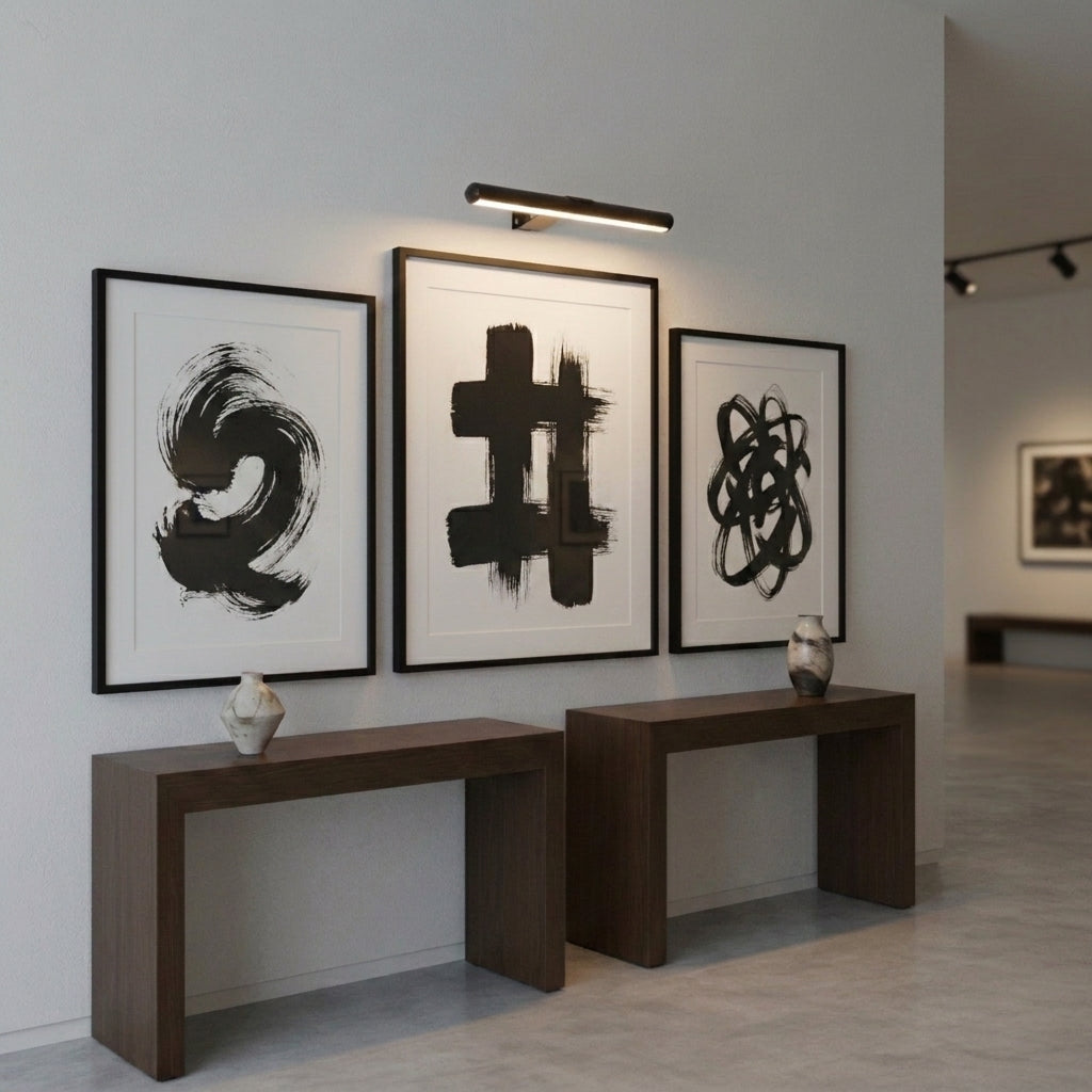 Tuvqi picture light illuminating abstract artwork above a console table