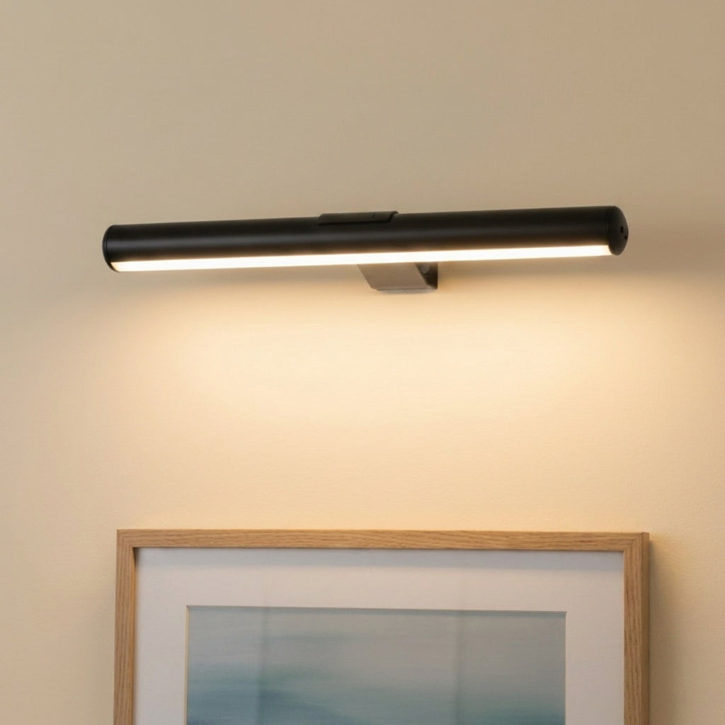 Tuvqi black wireless LED picture light illuminating framed artwork on a wall