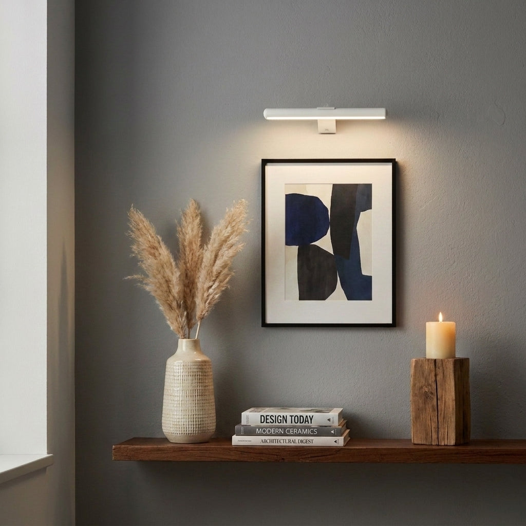 Tuvqi white wireless picture light above framed art on a corner shelf display