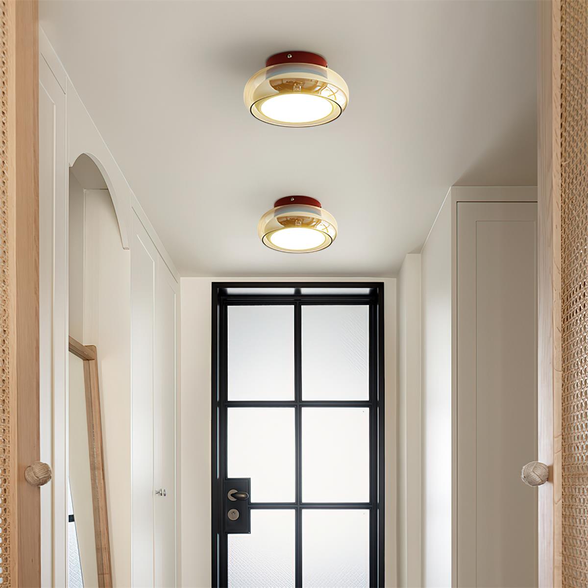 Pair of amber glass flush mount ceiling lights illuminating a modern hallway corridor