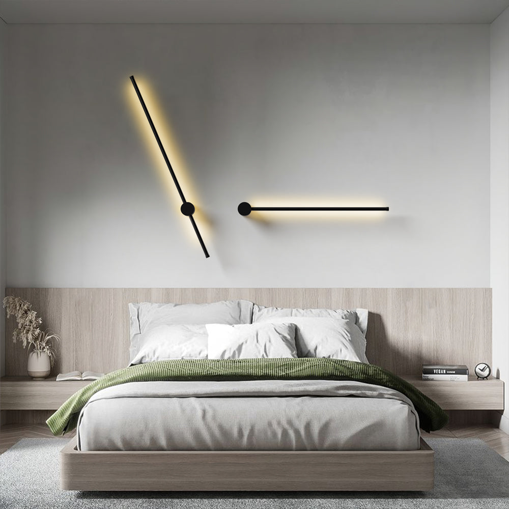 Pair of rotatable linear LED sconces styled horizontally and diagonally over a modern bedroom headboard