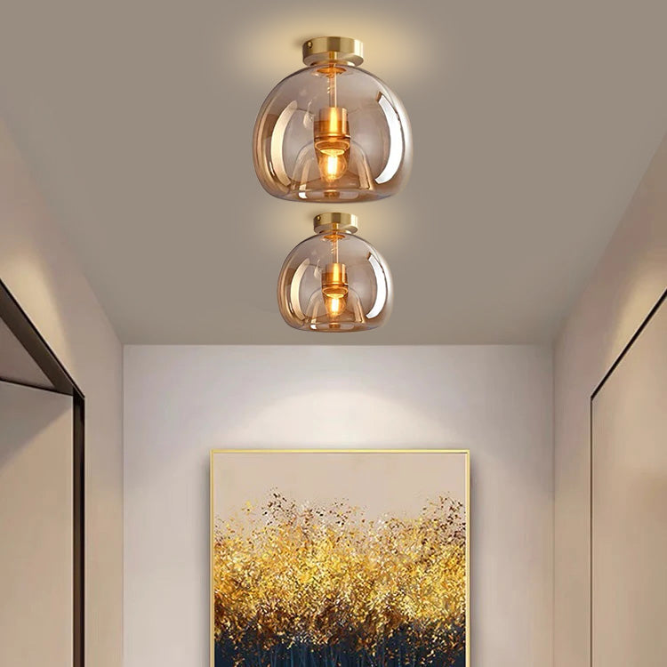 Two tall elegant amber glass dome ceiling lights illuminating a contemporary home interior