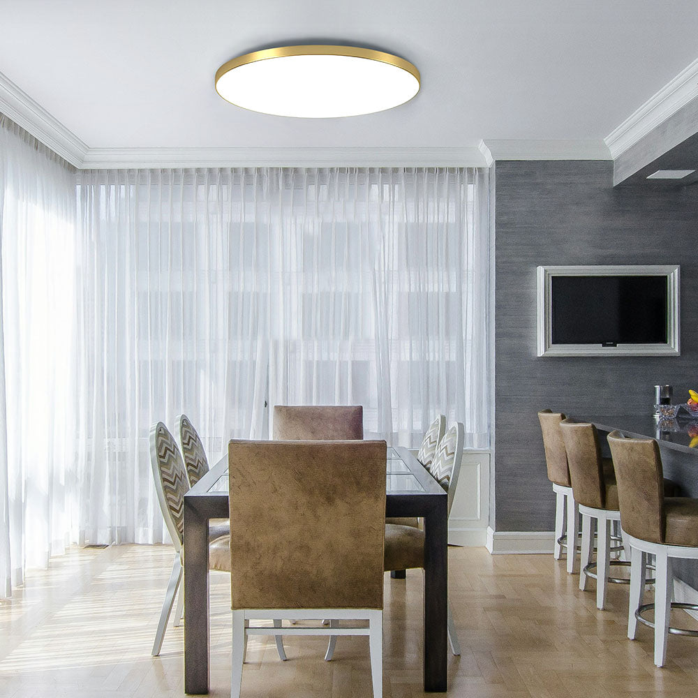 Modern gold round LED flush mount tywa ceiling light illuminating a contemporary dining room