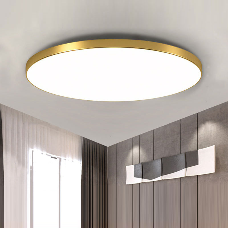 Close-up of an ultra-thin gold round LED flat panel tywa ceiling light installed on a white ceiling