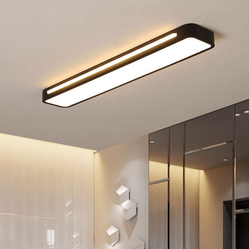 Close-up of an ultra-thin black linear LED ceiling light glowing in a contemporary room