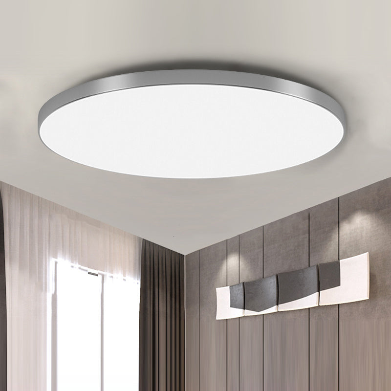 Ultra-thin silver modern round LED flush mount ceiling lamp isolated against a white ceiling