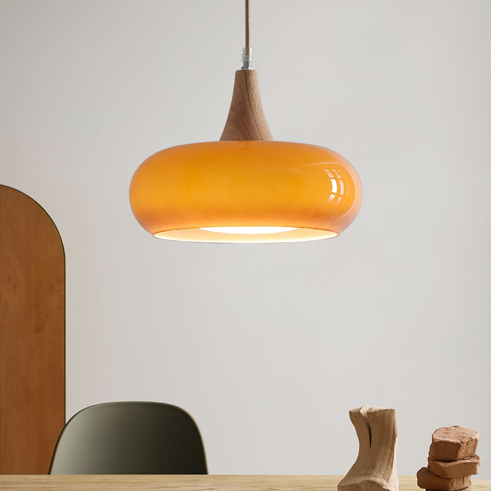 Orange glass dome utul pendant providing warm ambient lighting over a minimalist desk setup