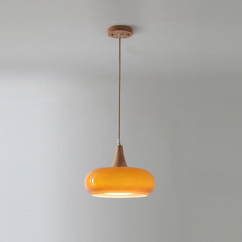 Single orange retro glass and wood utul ceiling lamp casting a soft downward glow