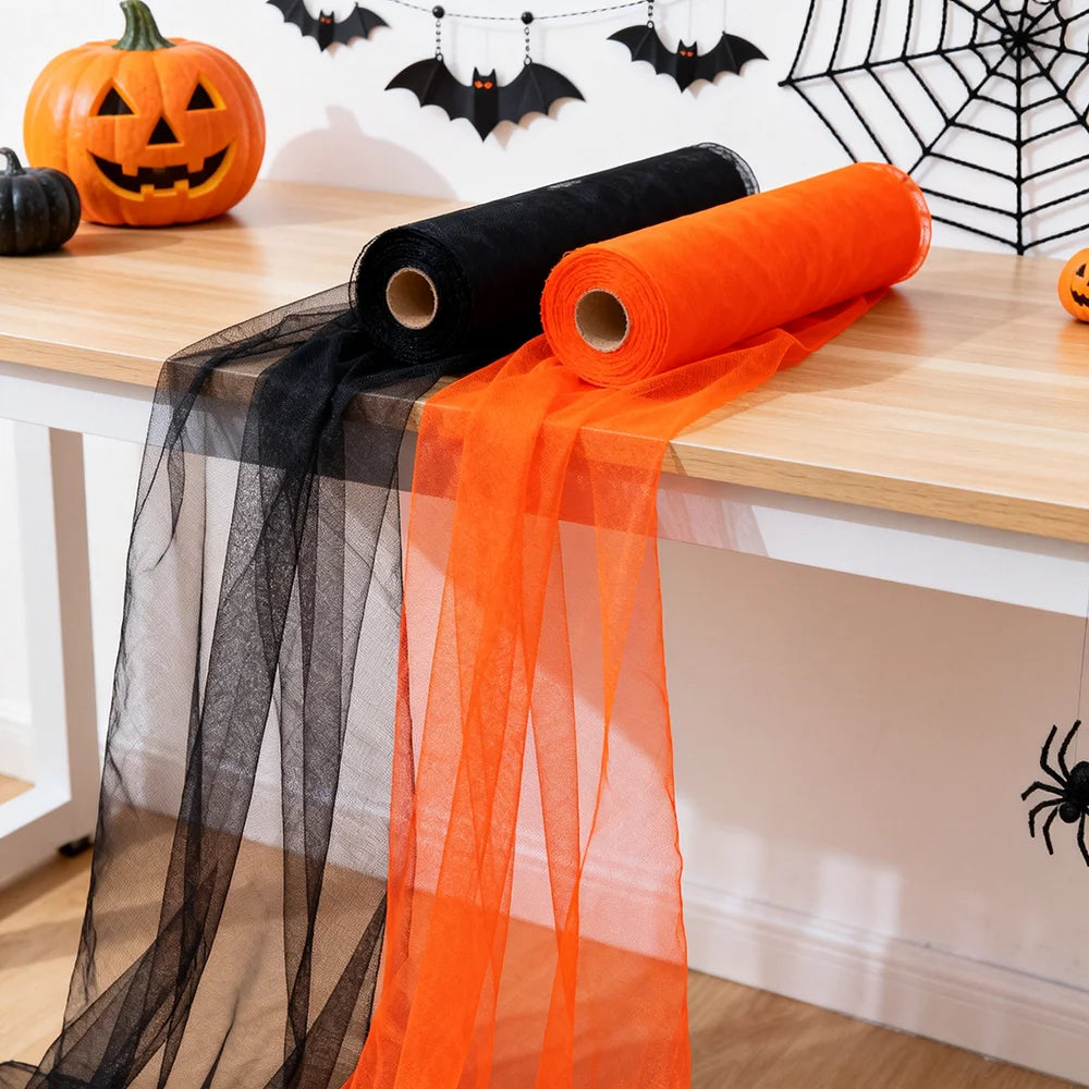 Vampnet orange and black sheer tulle fabric rolls on a table with Halloween pumpkins and bats