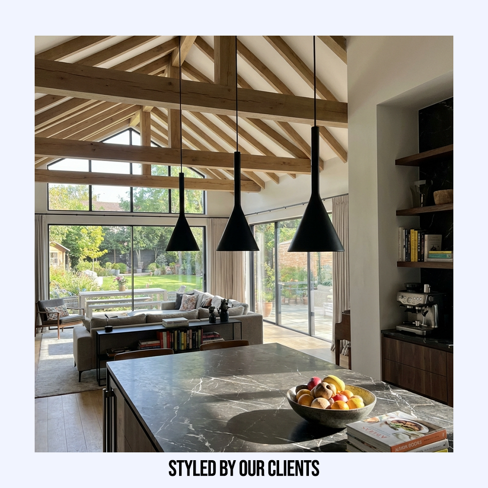 Three black minimalist resin pendants styled by clients in a modern kitchen with a vaulted wooden ceiling