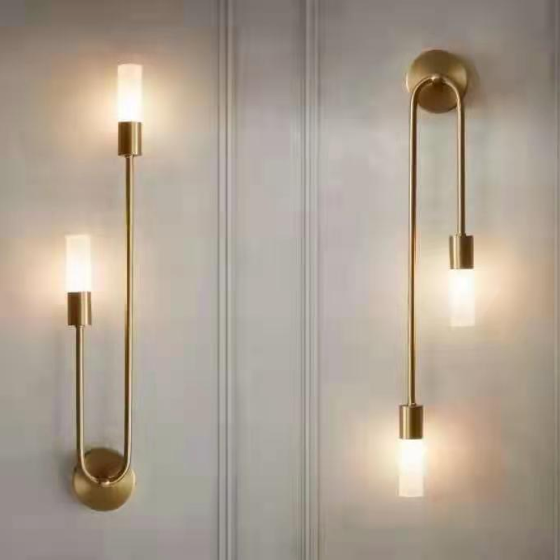 Pair of gold vergs hairpin wall lamps mounted symmetrically in a modern corridor