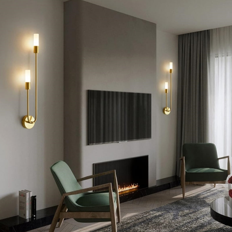 Pair of vergs elegant gold U-shaped sconces beautifully framing a modern fireplace in a living room