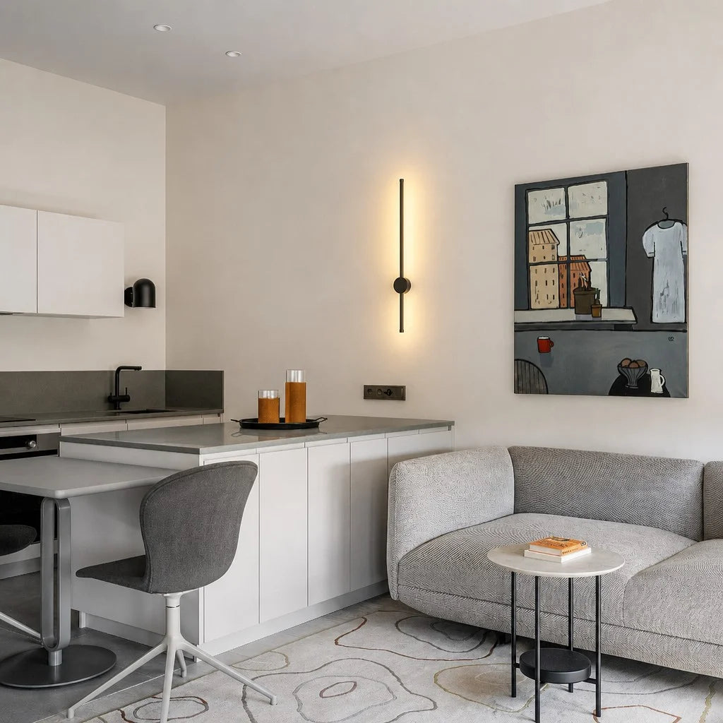 Vertical black linear LED wall light illuminating a contemporary kitchen and lounge