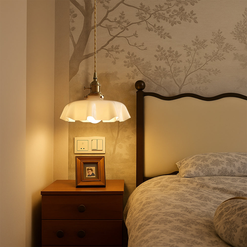Vintage scalloped glass pendant styled as an elegant bedside reading light in a romantic bedroom