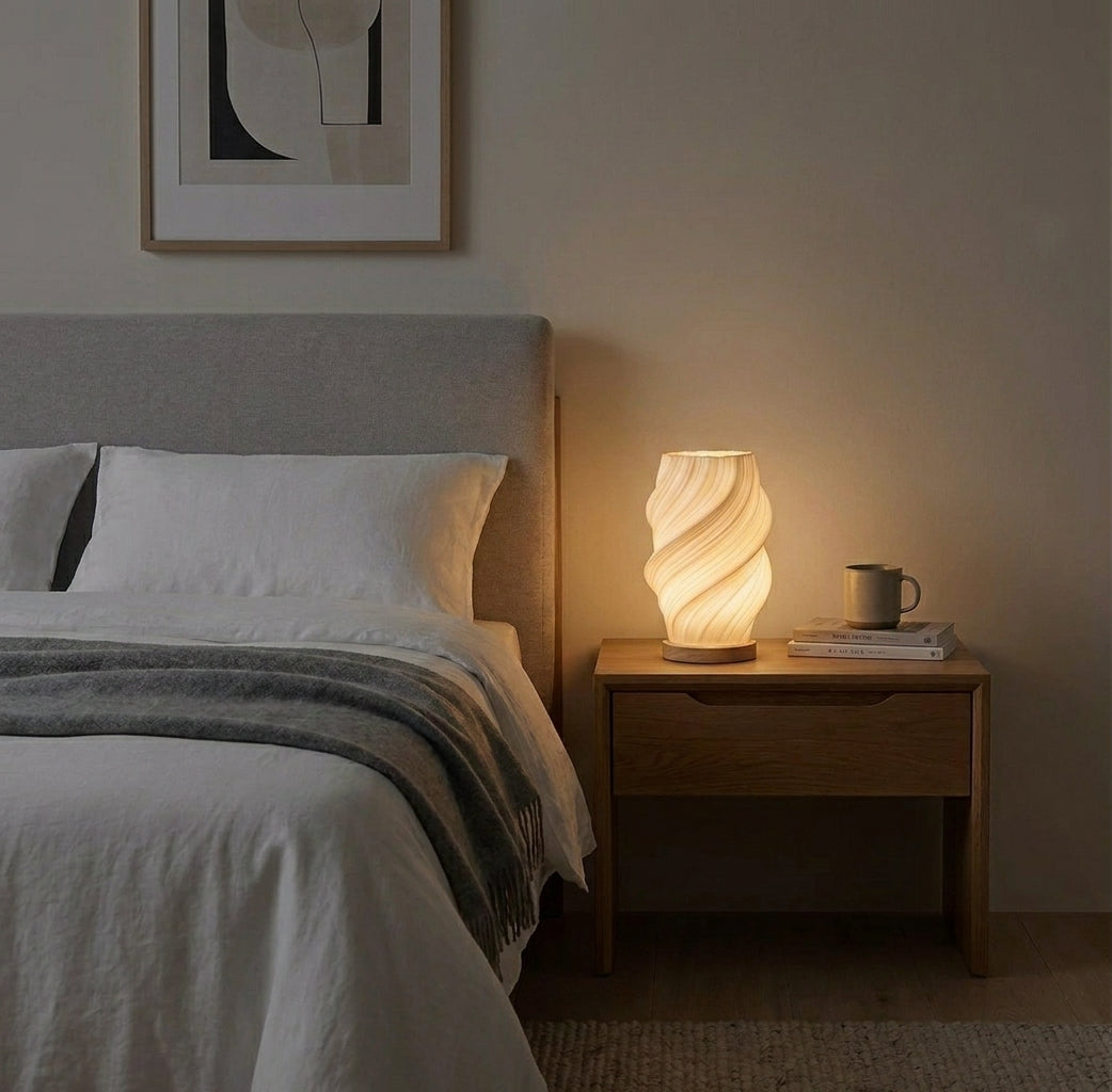 Volzi cream 3D wave table lamp on a bedside table next to a bed