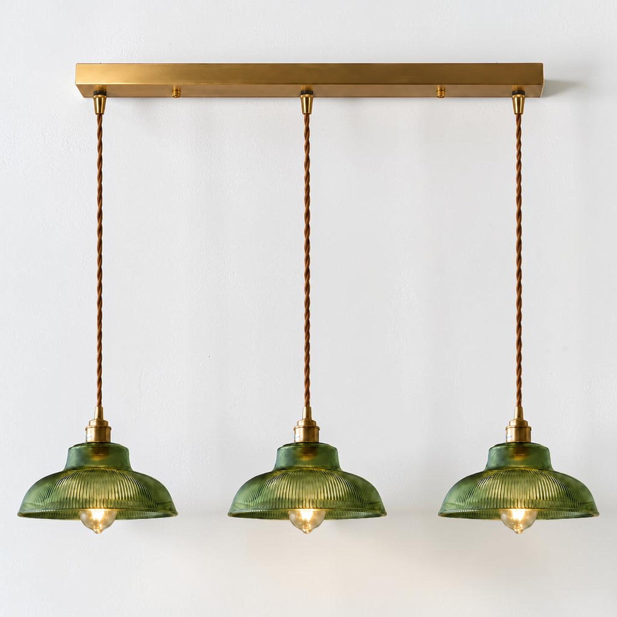 Vopzi 3-Light pendant fixture with brass base on a white background