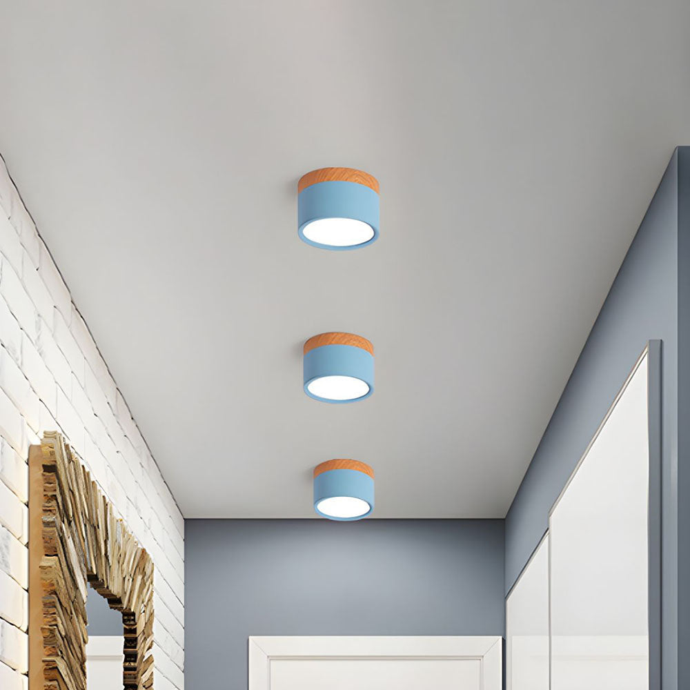 Three light blue Nordic cylinder surface vytri spotlights illuminating a bright hallway