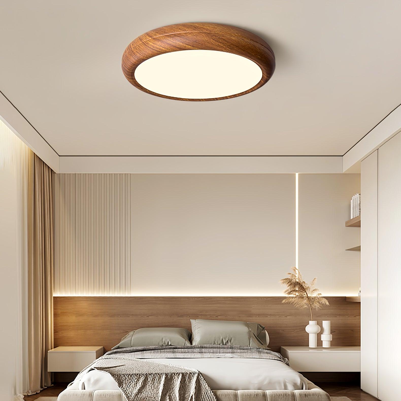 Curved walnut wood-style LED ceiling light illuminating a modern bedroom