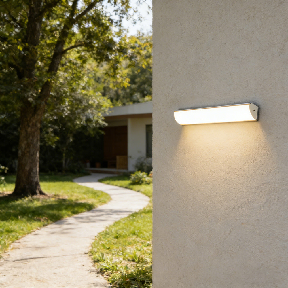 Waterproof linear LED wall light illuminating a lush green garden pathway